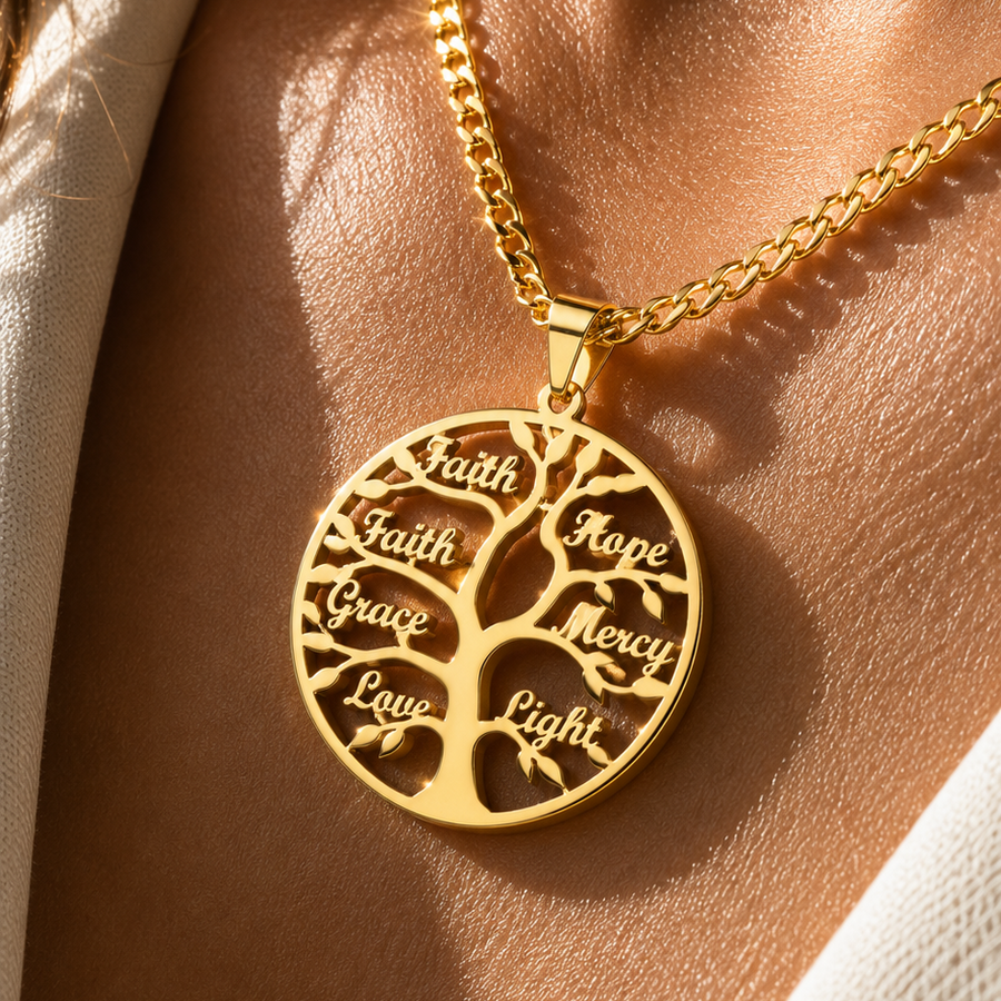 A gold tree-of-life pendant necklace worn on a model's neck, featuring engraved words like Faith, Hope, Mercy, and Love, set against a warm, sunlit background.