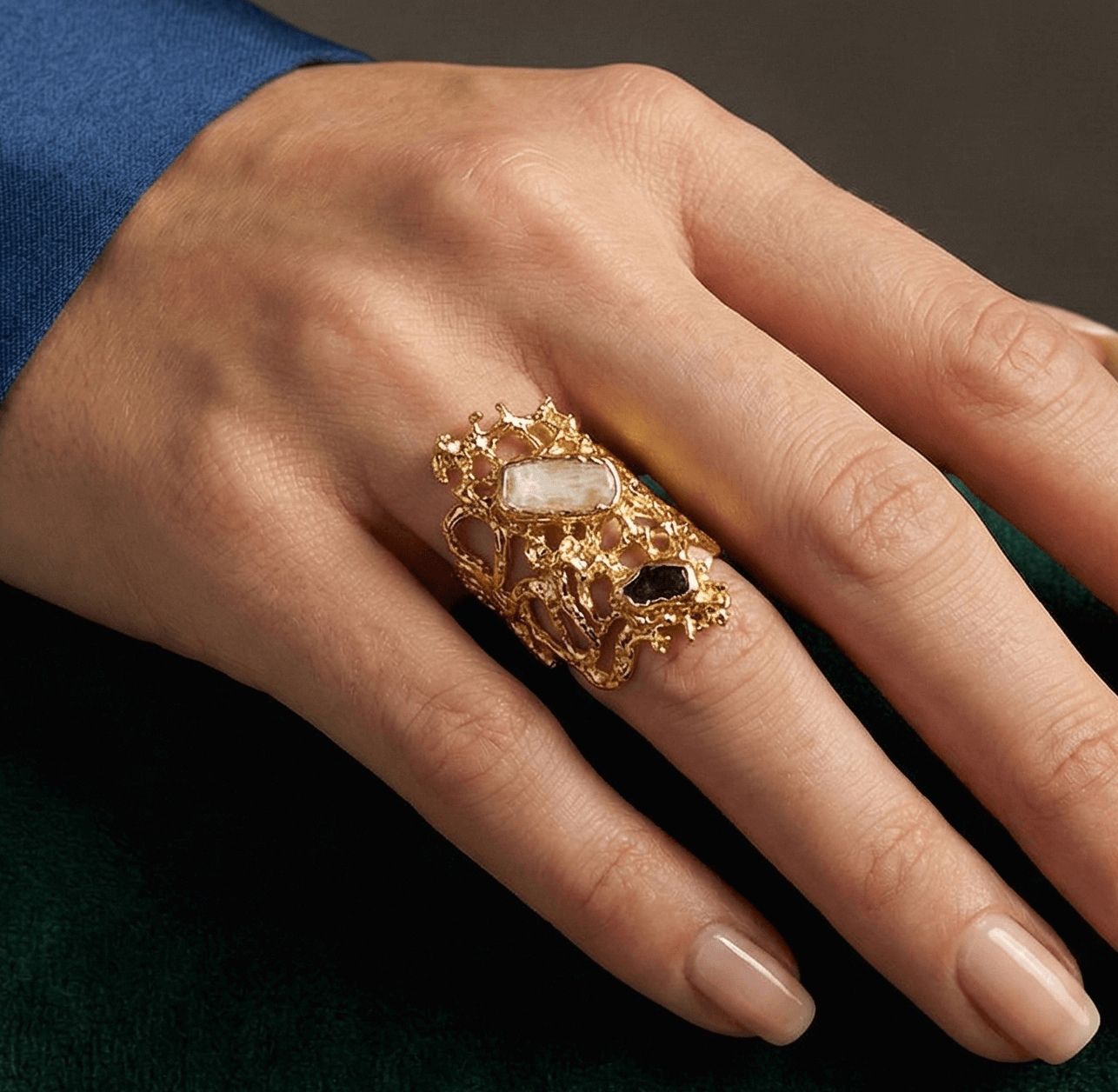 Hand wearing a gold ring with a green background