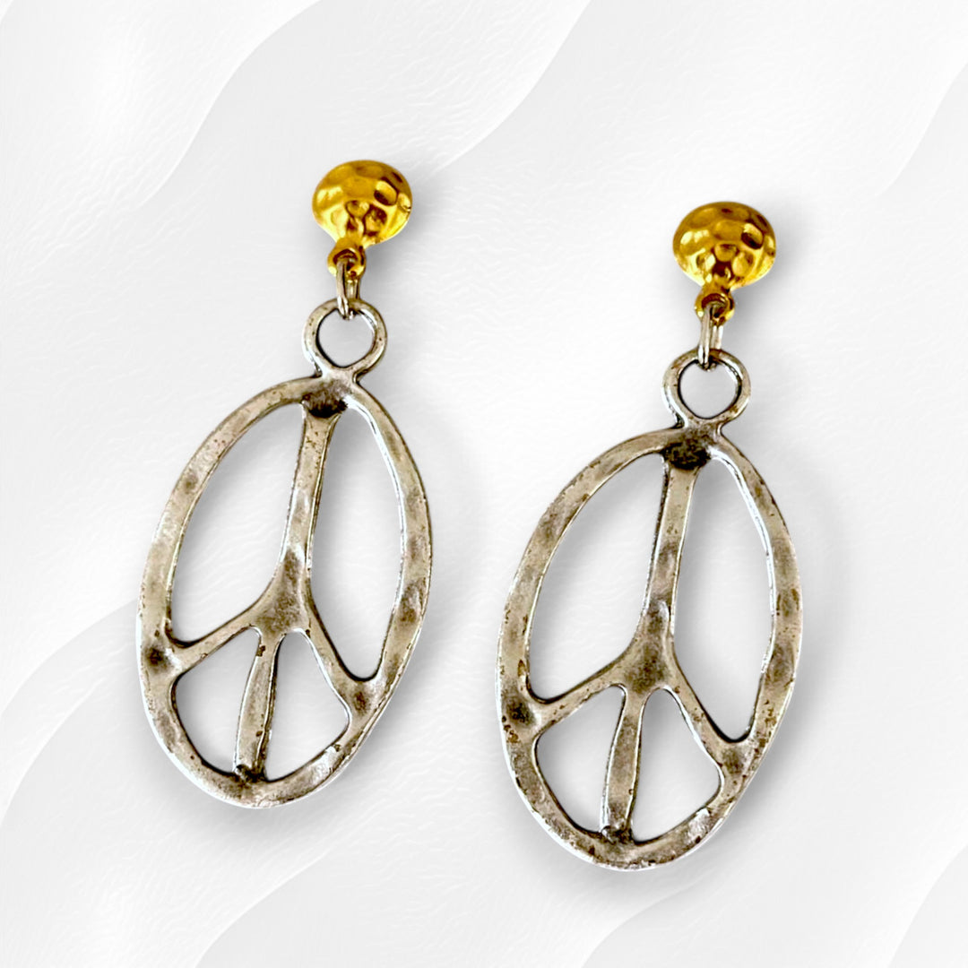 gold plated boho peace sign earrings on a textured background with rustic silver-tone finish.